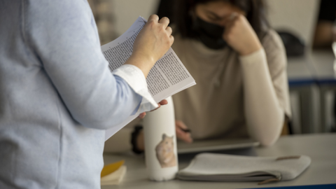 Lehrerin mit Dokument stehend vor einer Schülerin